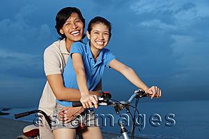 Asia Images Group - Couple on tandem bicycle, man embracing woman