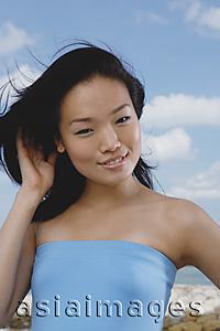 Asia Images Group - Woman in blue tube top, smiling at camera