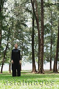 Asia Images Group - Young woman in traditional Chinese costume, standing amongst trees