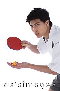 Asia Images Group - Young man with table tennis paddle and ball, preparing to serve