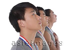 Asia Images Group - Three athletes with medals around their necks, standing in a row
