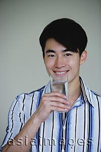 Asia Images Group - Young man holding glass of water, smiling