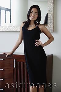 Asia Images Group - Young woman in black dress, hand on hip