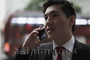 Asia Images Group - Young man talking on phone on busy street