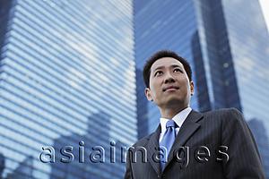 Asia Images Group - Mature man in a suit standing in front of a building