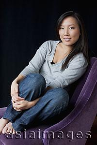 Asia Images Group - Woman sitting in chair smiling
