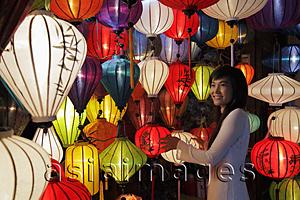 Asia Images Group - Young woman standing in front of colorful, hanging lanterns