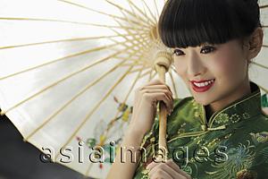 Asia Images Group - Young woman wearing a traditional Chinese dress and holding an umbrella
