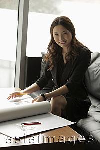 Asia Images Group - Young woman working on plans in an office