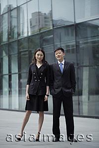 Asia Images Group - Young man and woman wearing suits, in front of a building