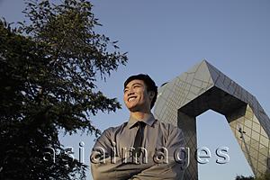 Asia Images Group - Young man standing in front of CCTV Building, Beijing, China