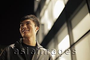 Asia Images Group - Young man walking on the street at night