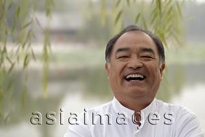 Asia Images Group - Head shot of older man laughing outdoors