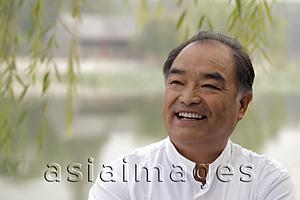 Asia Images Group - Head shot of older man smiling outdoors.
