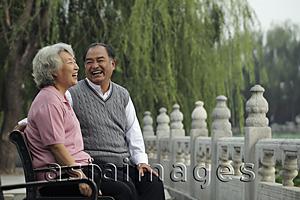 Asia Images Group - Older couple laughing at each other in a park