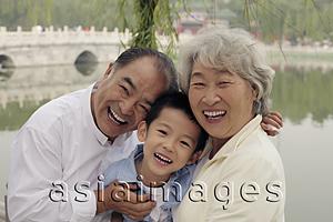 Asia Images Group - Grandma, grandfather and grandson hugging in a park