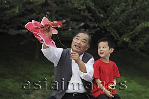 Asia Images Group - Grandfather and grandson playing with a kite