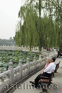 Asia Images Group - Older couple sitting on park bench looking at view