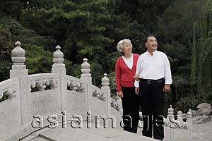 Asia Images Group - Older couple standing on a bridge looking at view