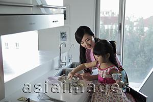 Asia Images Group - Mother teaching daughter how to cook