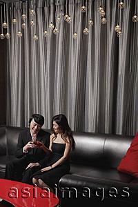 Asia Images Group - Young couple sitting in club having a drink