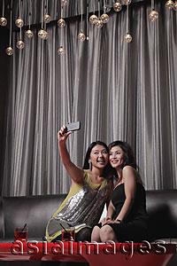 Asia Images Group - Two women taking photos of themselves in a club