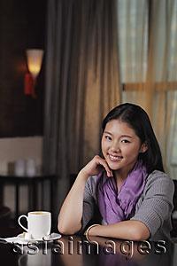 Asia Images Group - Young woman sitting in cafe with coffee cup
