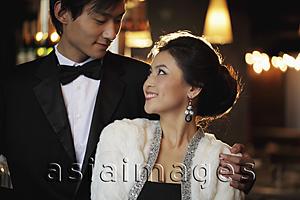 Asia Images Group - Young couple elegantly dressed looking at each other