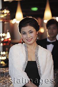 Asia Images Group - Woman dressed up at night with man in tuxedo in background