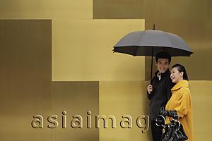 Asia Images Group - Young couple walking on street holding an umbrella