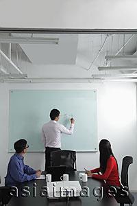 Asia Images Group - Man writing on white board during a meeting