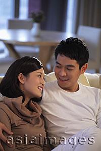 Asia Images Group - Young couple at home looking at each other and smiling