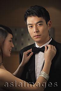 Asia Images Group - Young man getting his bow tie straightened by a woman