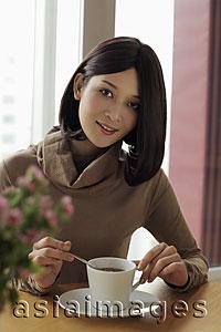 Asia Images Group - Young woman sitting down and drinking coffee