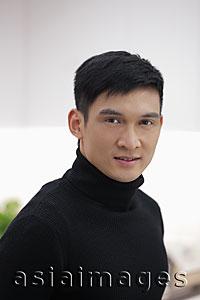 Asia Images Group - Head shot of young man in black polo neck