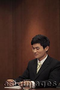 Asia Images Group - Young man sitting at desk