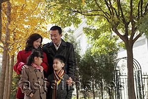 Asia Images Group - Family of four standing together in front of their home