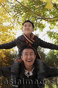 Asia Images Group - Young boy on dad's shoulders looking up