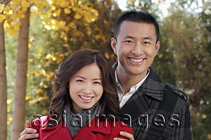 Asia Images Group - Young couple standing together under the trees