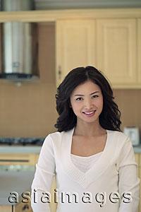 Asia Images Group - Young woman smiling in her kitchen