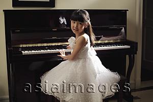 Asia Images Group - Young girl playing piano in white dress