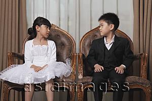 Asia Images Group - Young boy and girl dressed in nice clothes looking at each other