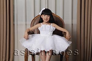 Asia Images Group - Young girl dress up in white dress sitting in nice chair