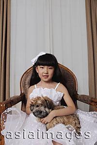 Asia Images Group - Young girl dressed up in white dress holding a puppy