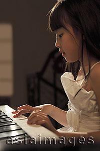 Asia Images Group - Profile of young girl playing piano