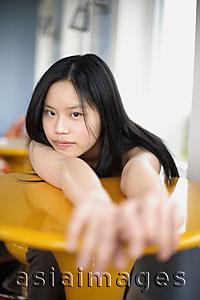 Asia Images Group - Young woman stretching her arms out on a table