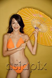 AsiaPix - Young woman in bikini, holding umbrella, smiling