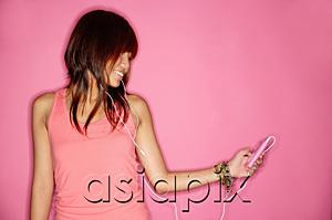 AsiaPix - Young woman holding mp3 player, looking away