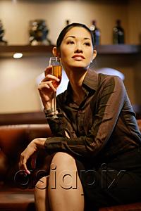 AsiaPix - Woman with champagne glass, legs crossed, looking away
