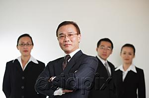 AsiaPix - Businessman with arms crossed, people in the background